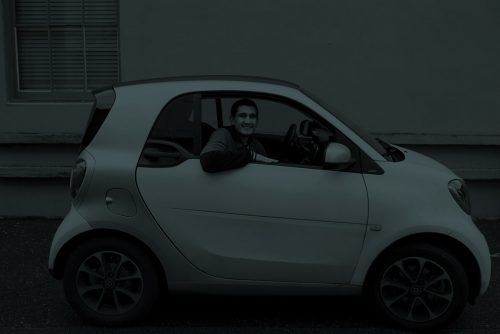 a dark image of a man driving an electric car