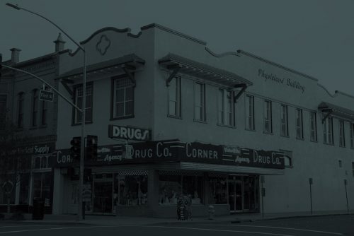 a dark image of corner drug building facade